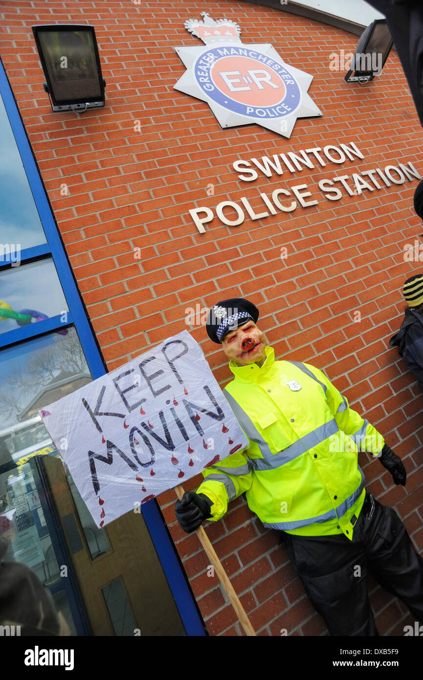 Swinton, Salford, Manchester, UK . 22nd March 2014. Anti-fracking campaigners protest outside Swinton police station, Salford, Manchester. Protester dressed as a policeman wearing a pig mask poses below the police station sign on the wall behind. Credit:  Dave Ellison/Alamy Live News Stock Photo