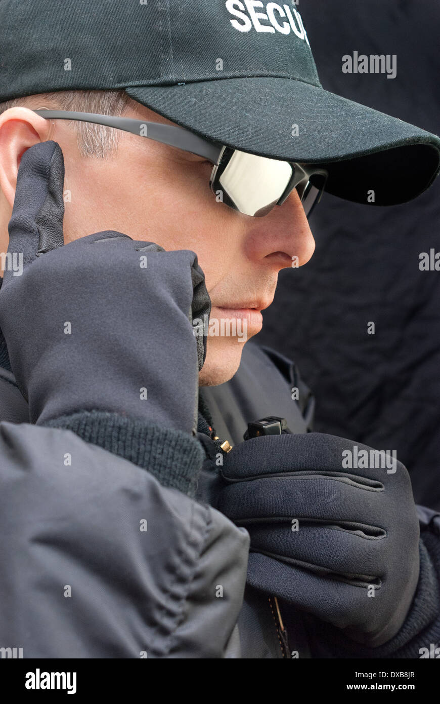 Close-up of a close protection officer listening to his earpiece. Stock Photo