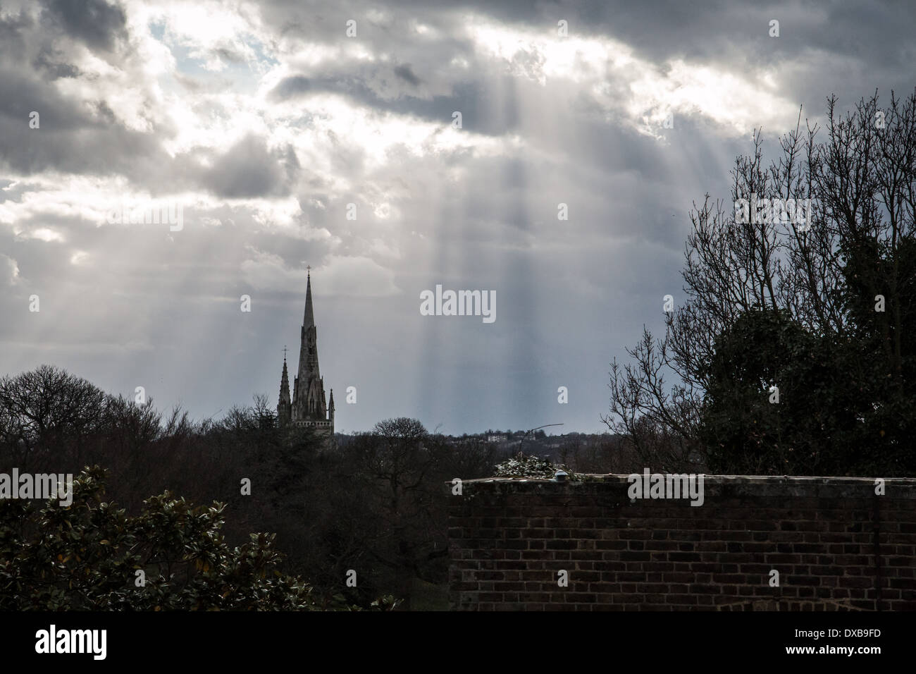 Steeple with cloudy sky and rays of light Stock Photo