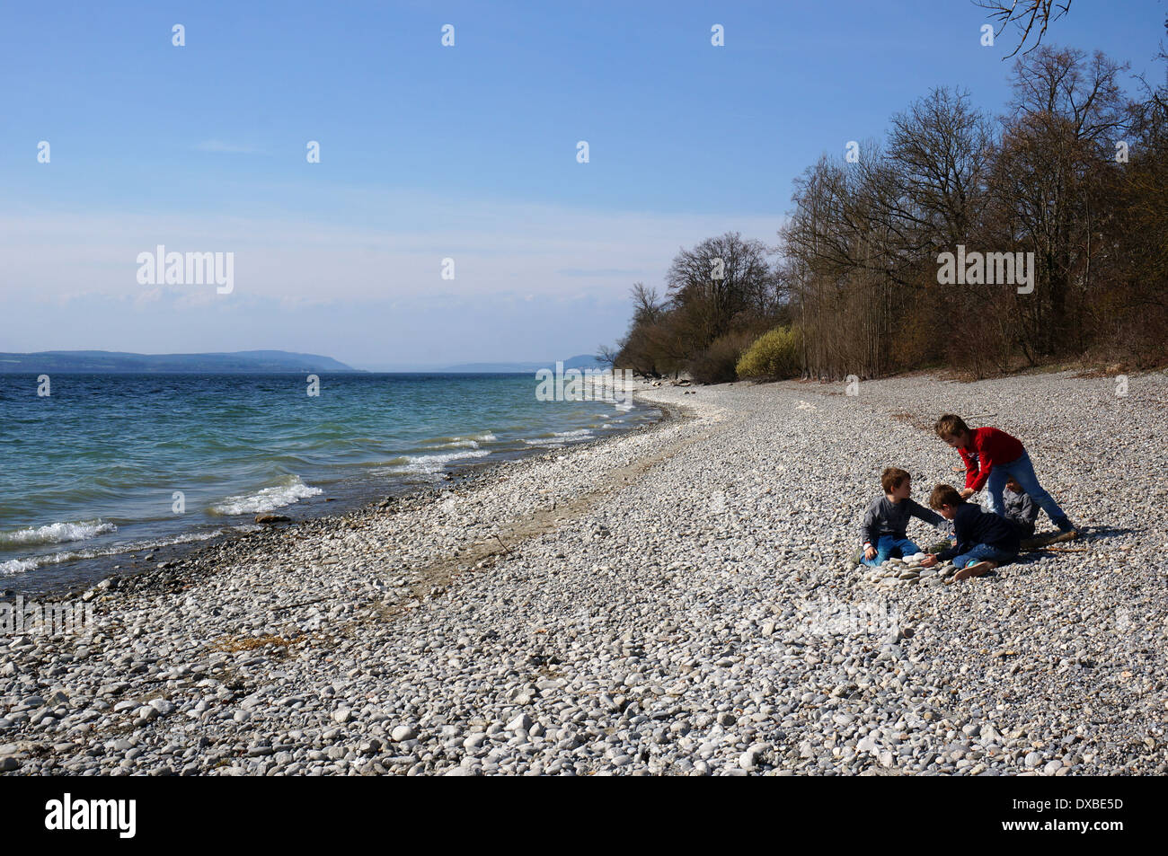 Three children enjoying springtime outdoor lake of constance Stock Photo