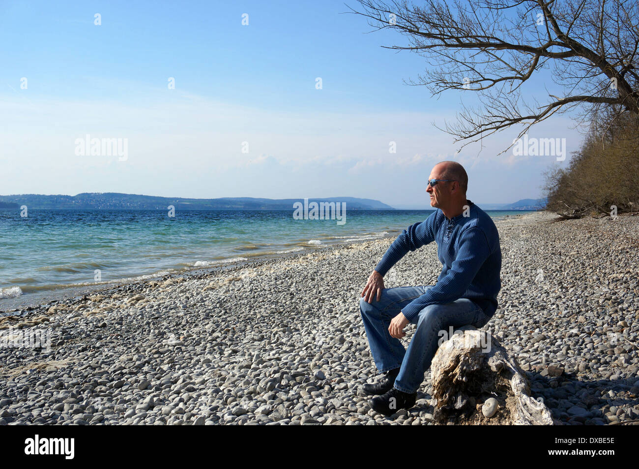 A 50 plus man enjoying life during a walk in spring at the beautiful lake of constance Stock Photo