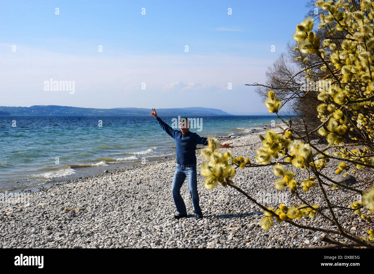A 50 plus man enjoying life during a walk in spring at the beautiful lake of constance Stock Photo