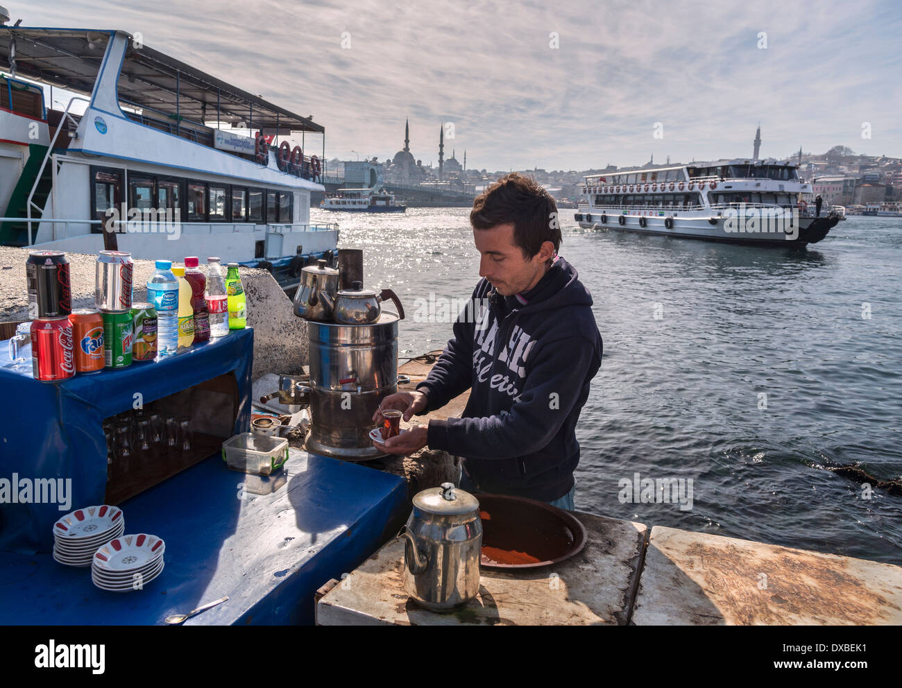 A tea vendor on Karakoy waterfront with the Golden Horn, Yeni mosque at