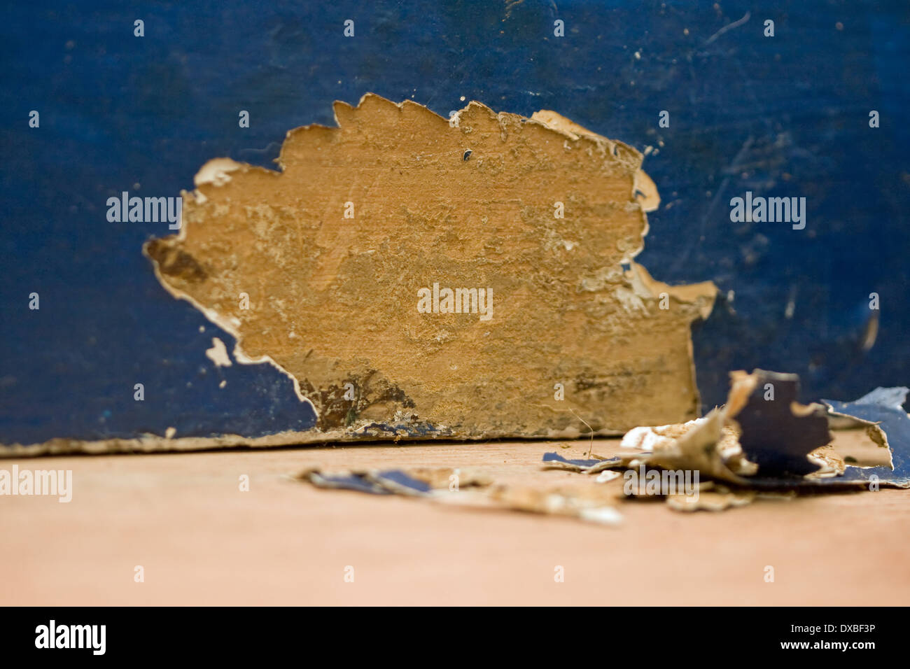 Paint flakes and bare wood under layers of paint on a length of