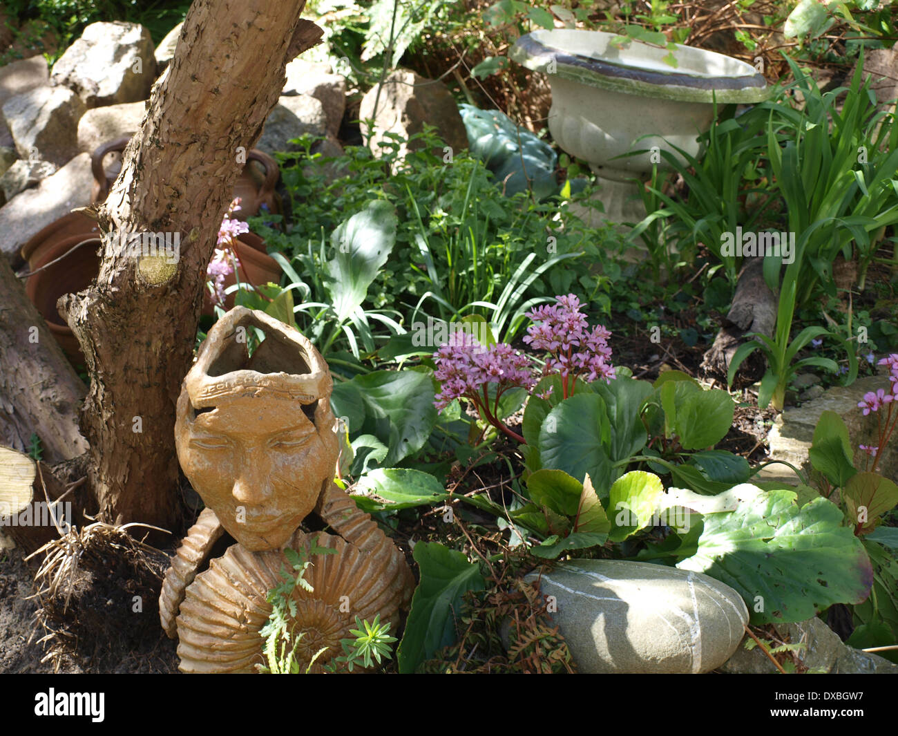 view of statue, plants and rockery in garden Stock Photo - Alamy