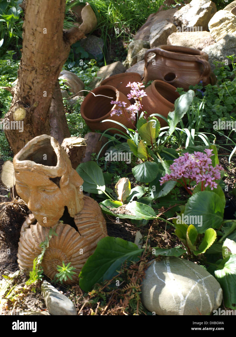 view of statue, plants and rockery in garden Stock Photo - Alamy