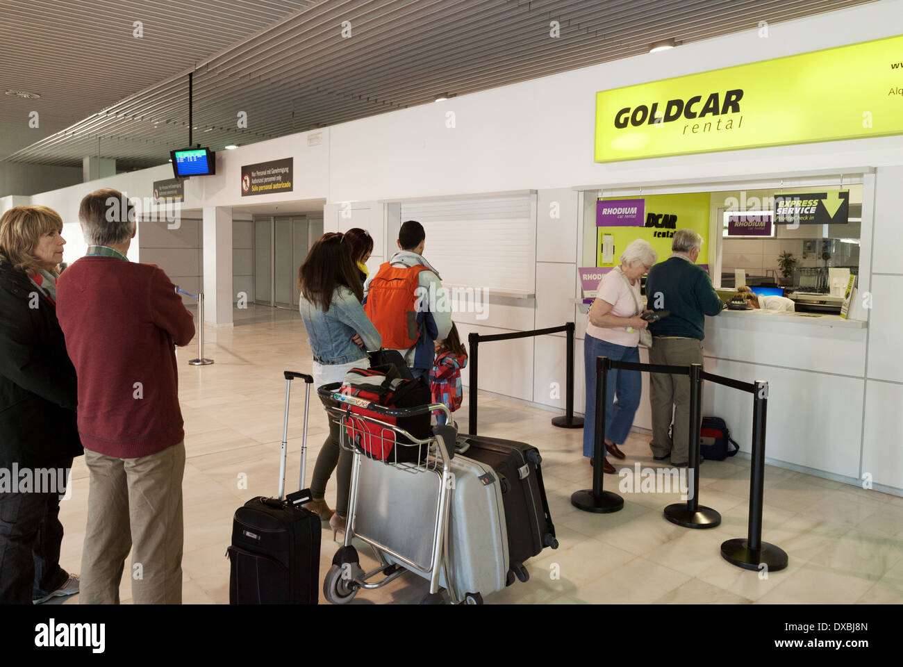 People waiting in a queue at the Goldcar rental hire car desk counter, Almeria airport, Spain Europe Stock Photo