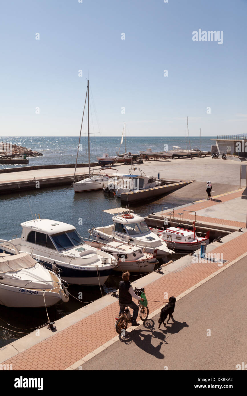 A man walking his dog by the marina and coast, the Spanish fishing village of Villaricos, Almeria, Andalusia, Spain Europe Stock Photo