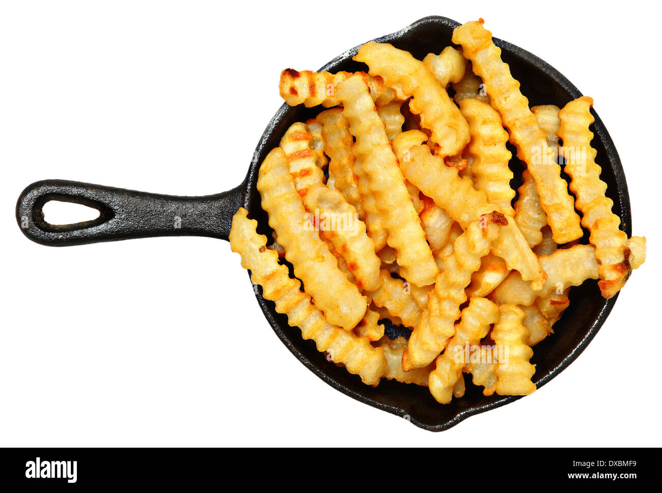 Oven Baked Crinkle Fries in Cast Iron Skillet over white. Stock Photo