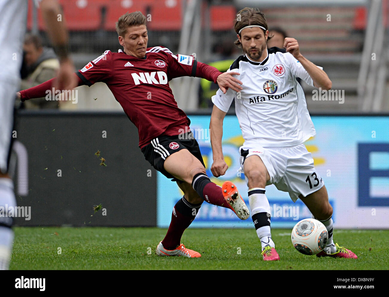 Nuerenberg, Germany. 23rd Mar, 2014. Nurenberg's Mike Frantz (L) and Frankfurt's Martin Lanig vie for the ball during the Bundesliga soccer match between 1. FC Nuerenberg and Eintracht Frankfurt at the Grundig Stadion in Nuerenberg, Germany, 23 March 2014. Pinola got the red card after this. Photo: Rene Ruprecht/dpa (ATTENTION: Due to the accreditation guidelines, the DFL only permits the publication and utilisation of up to 15 pictures per match on the internet and in online media during the match.)/dpa/Alamy Live News Stock Photo