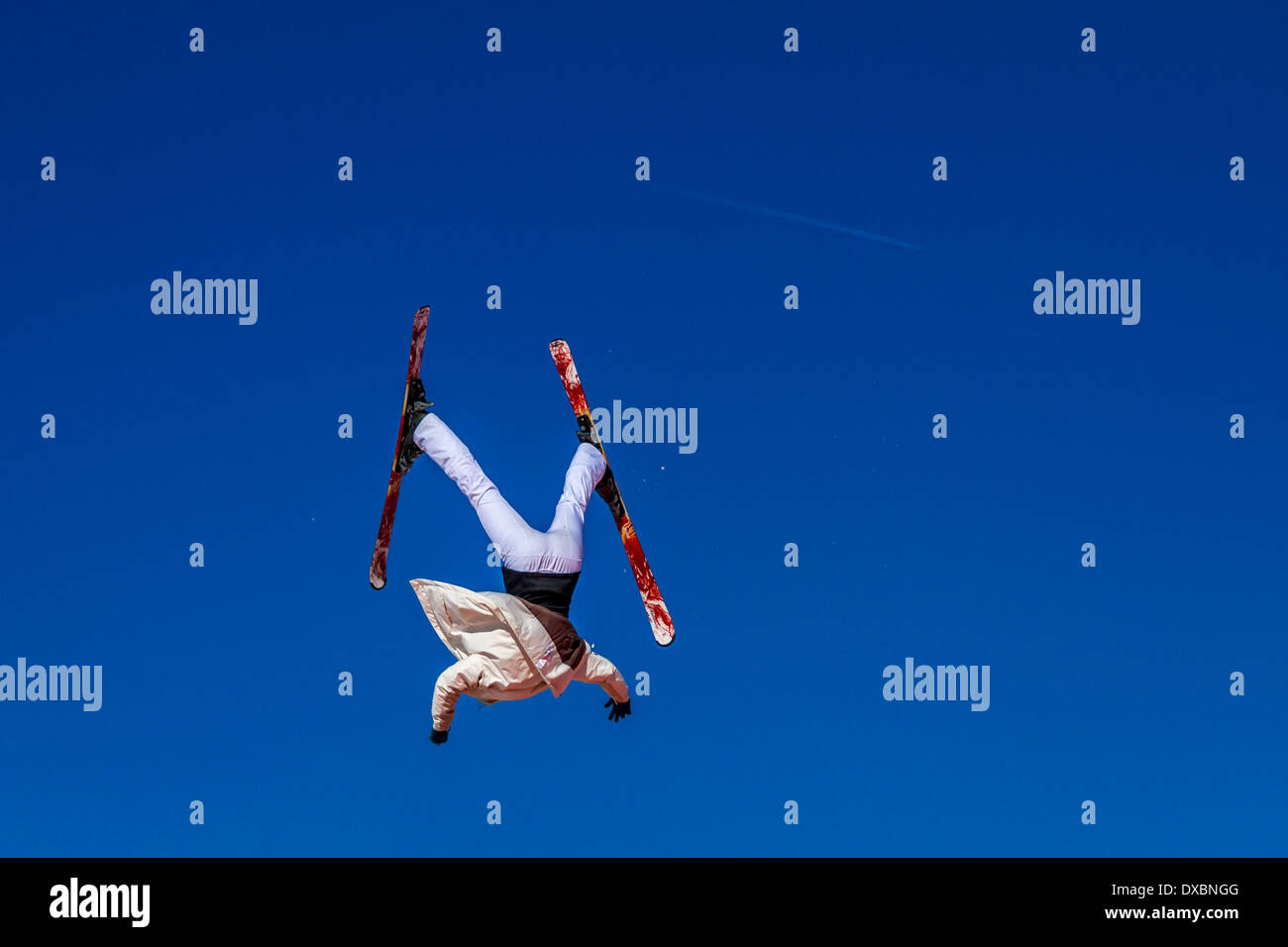 Skier upside down and out of control against a blue sky Stock Photo