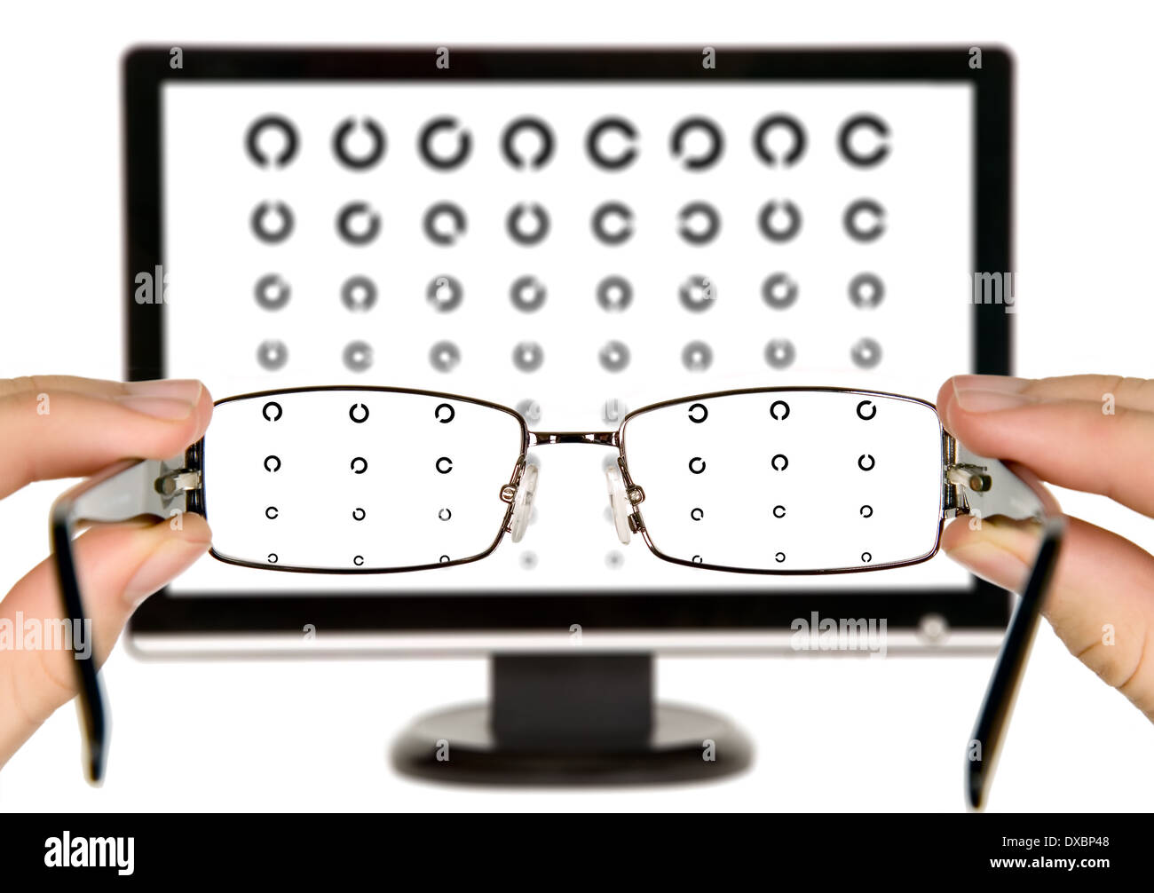 Man is viewing to eye examination chart on display through eyeglasses Stock Photo