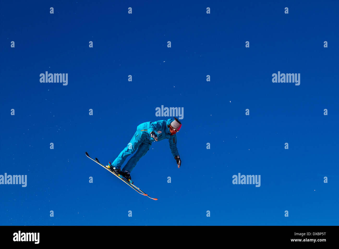 Ski instructor practising and demonstrating ski jumping, landing on a giant airbag Stock Photo