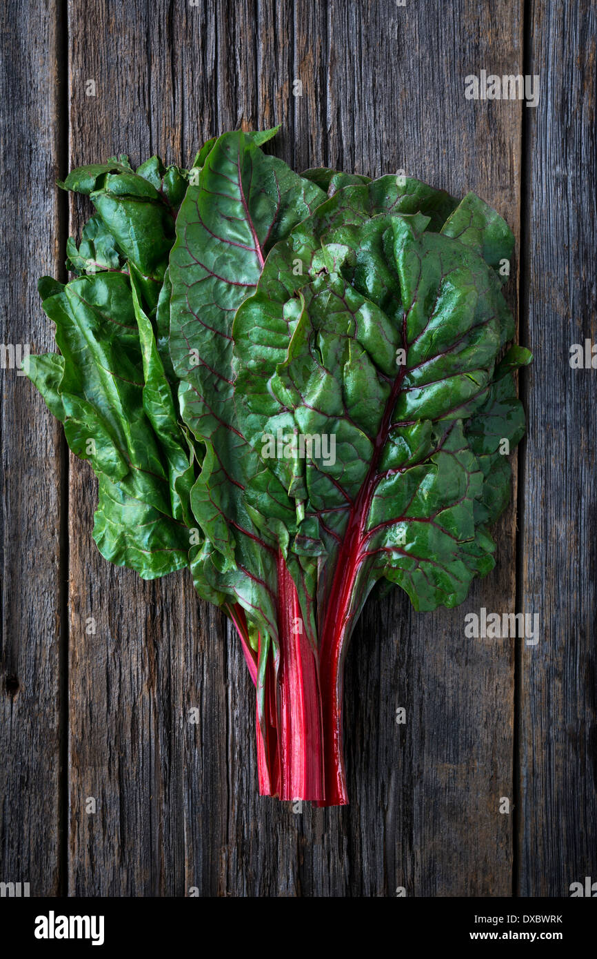 Organic red ruby swiss chard raw on rustic wood Stock Photo