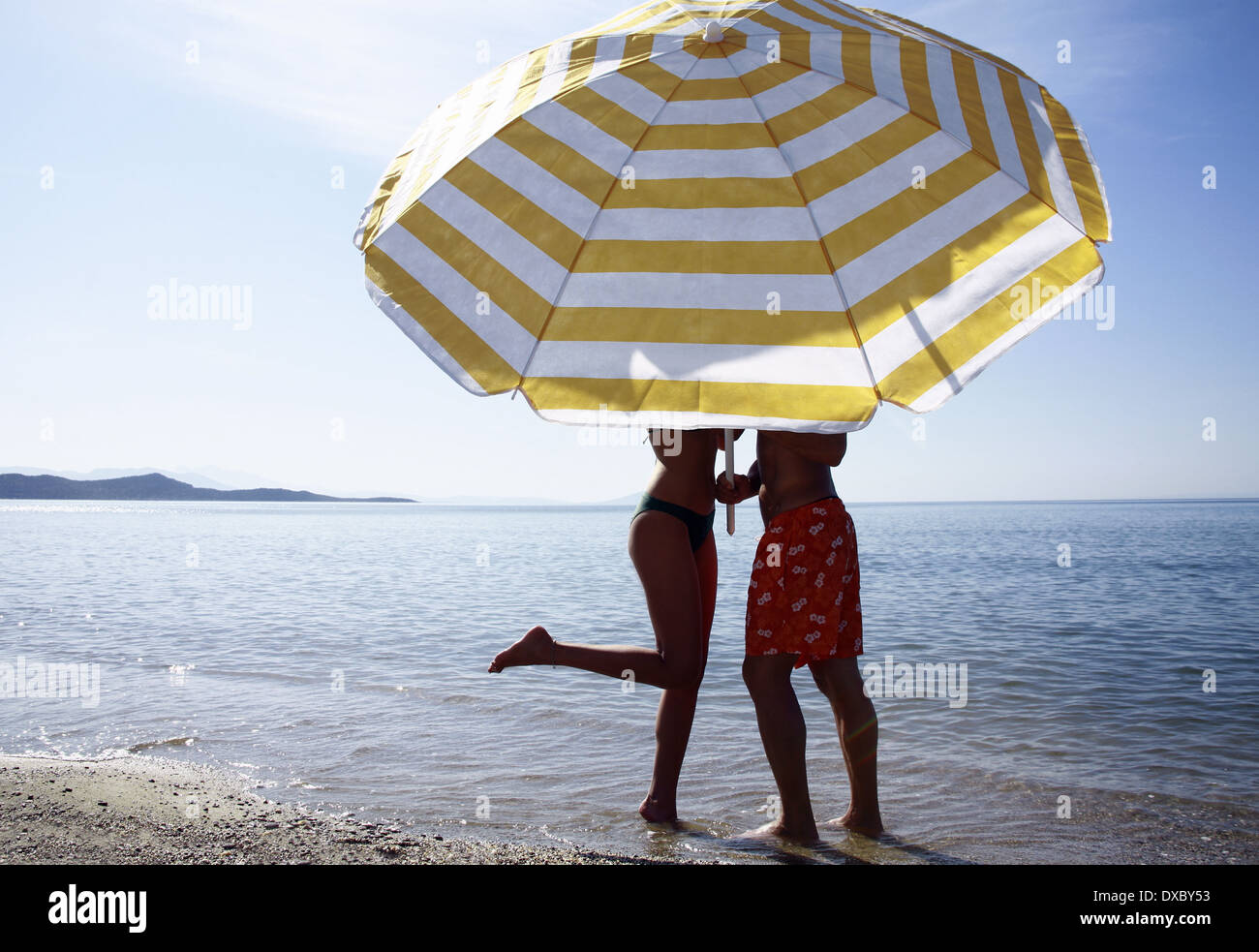 Attractive Couple Playing At The Sea. Girl Flirts With Her Boyfriend: She  Took His Swimming Trunks And Runs Away From Him Stock Photo, Picture and  Royalty Free Image. Image 93837530.