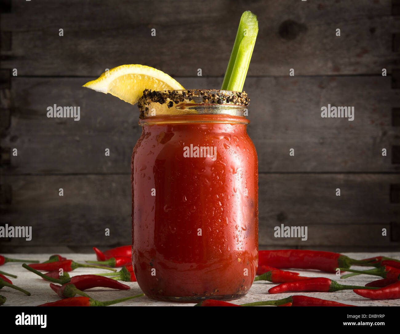 Bloody Mary or Bloody Caesar with celery in mason jar rimmed with black pepper Stock Photo