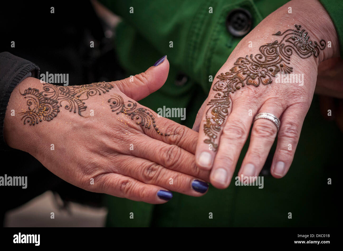 Brick Lane, London, UK, 23 March 2014.  Brick Lane hosts the Taste Brick Lane Awards 2014, to celebrate the cuisine of the area.  Two ladies show off their henna tattoos. Credit:  Stephen Chung/Alamy Live News Stock Photo