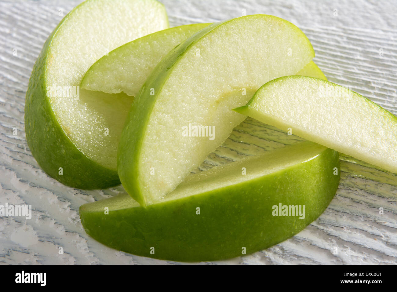 Green apple slices on white stained wood Stock Photo