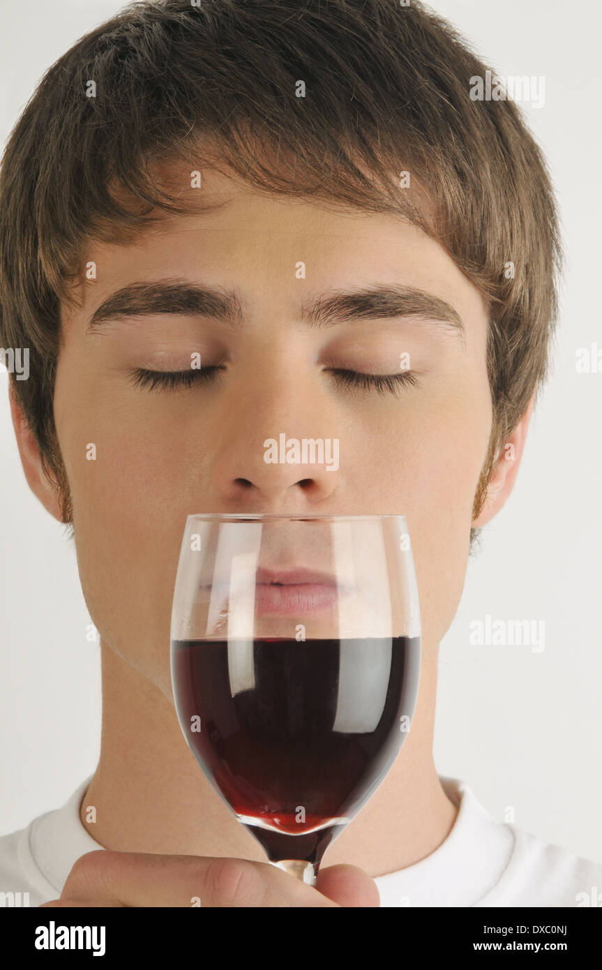 Young male adult smelling a glass of red wine Stock Photo - Alamy