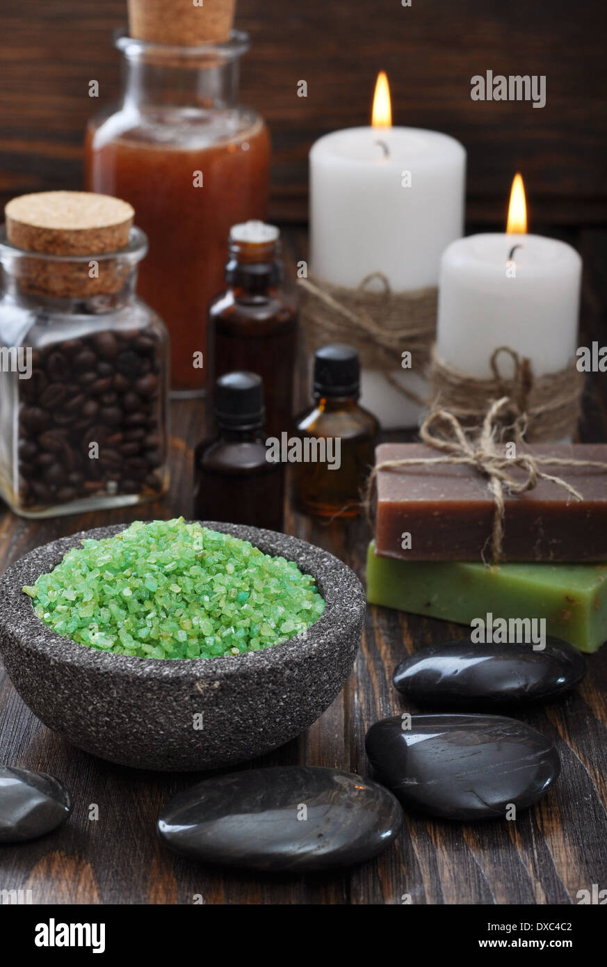 Spa composition with green sea salt and massaging stones on wooden background Stock Photo