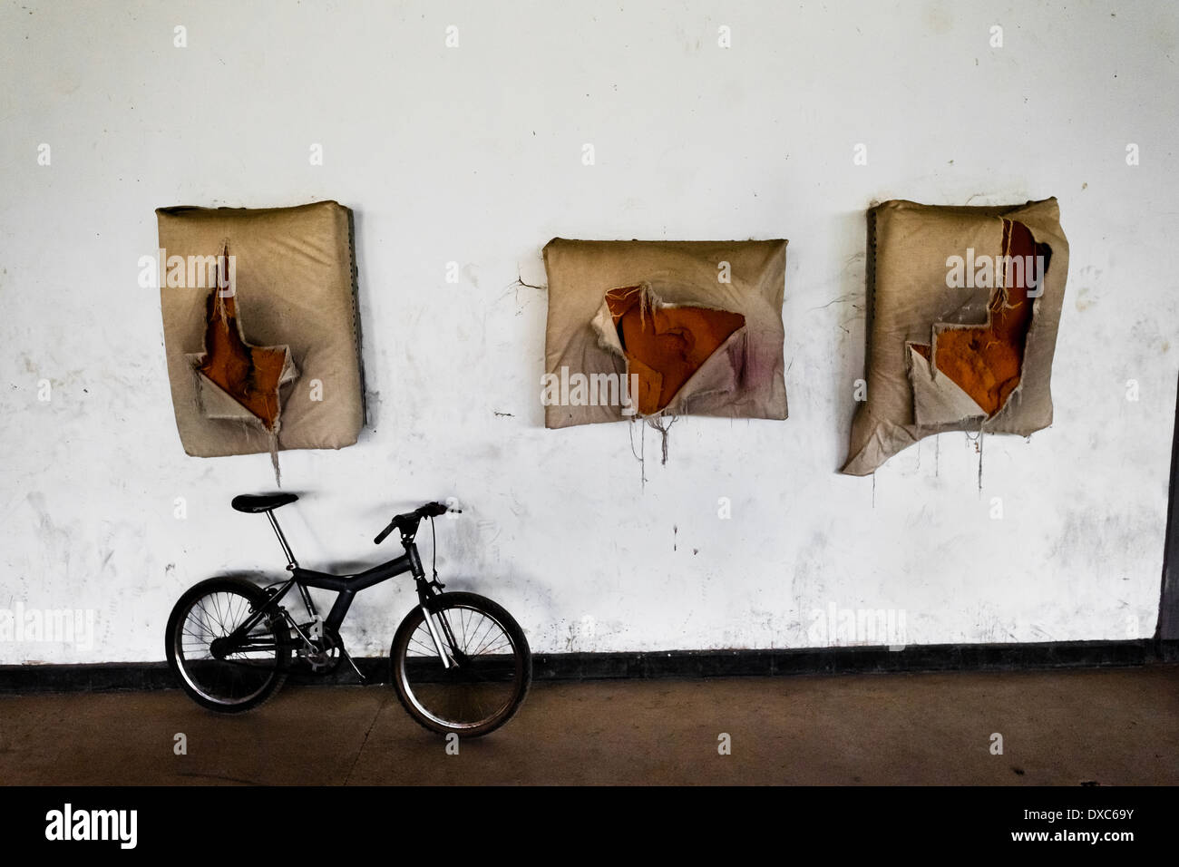Broken punching bags are seen mounted on the wall in the boxing gym in