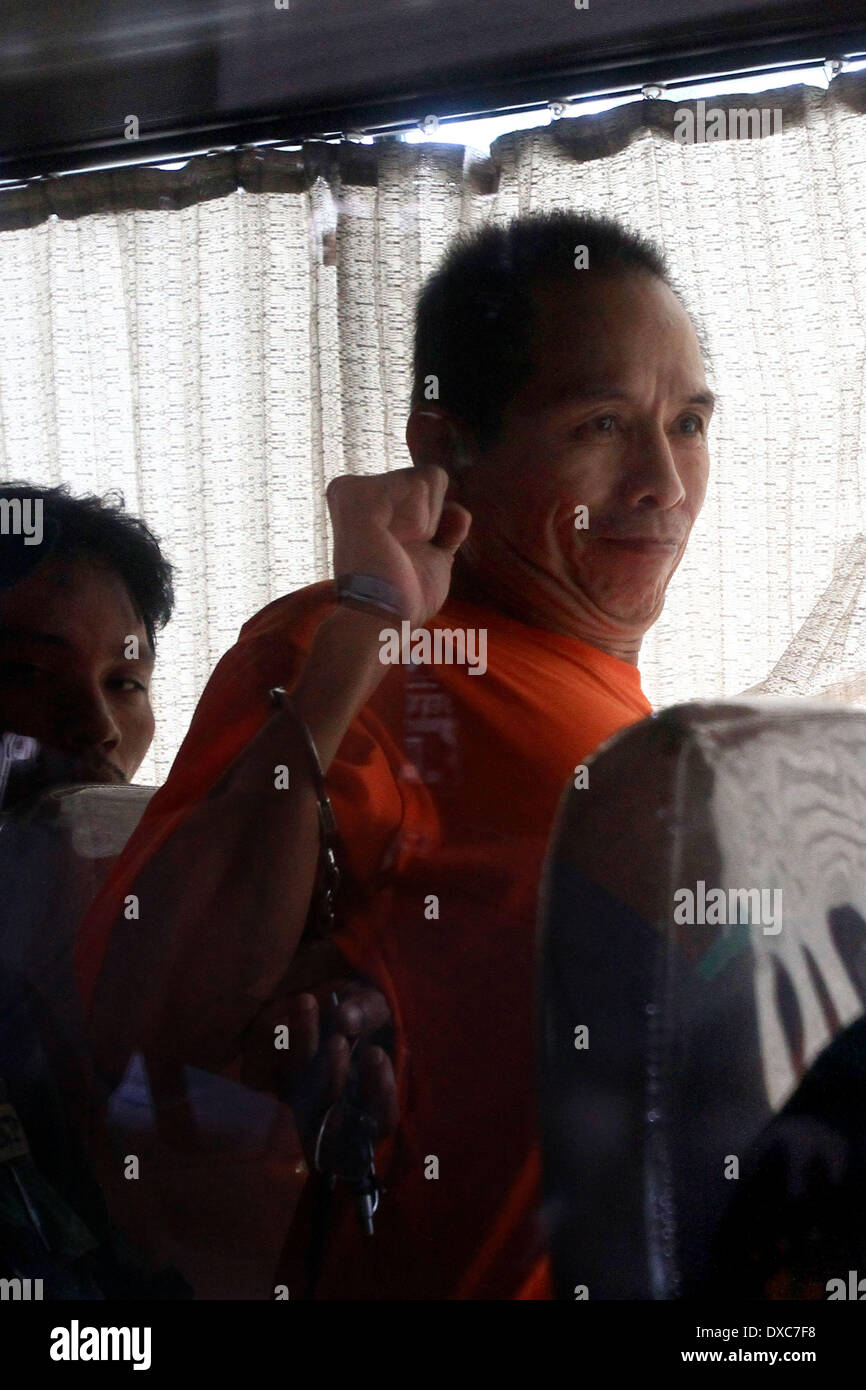 Quezon City, Philippines. 24th Mar, 2014. Benito Tiamzon (R), chairman of the Communist Party of the Philippines (CPP)-NPA, raises his fist in a police van after inquest proceeding at Camp Crame in Quezon City, the Philippines, March 24, 2014. The Communist Party of the Philippines, New People's Army and National Democratic Front (CPP-NPA-NDF) vowed Monday to pursue armed struggle despite the arrest of their two top leaders. Credit:  Rouelle Umali/Xinhua/Alamy Live News Stock Photo