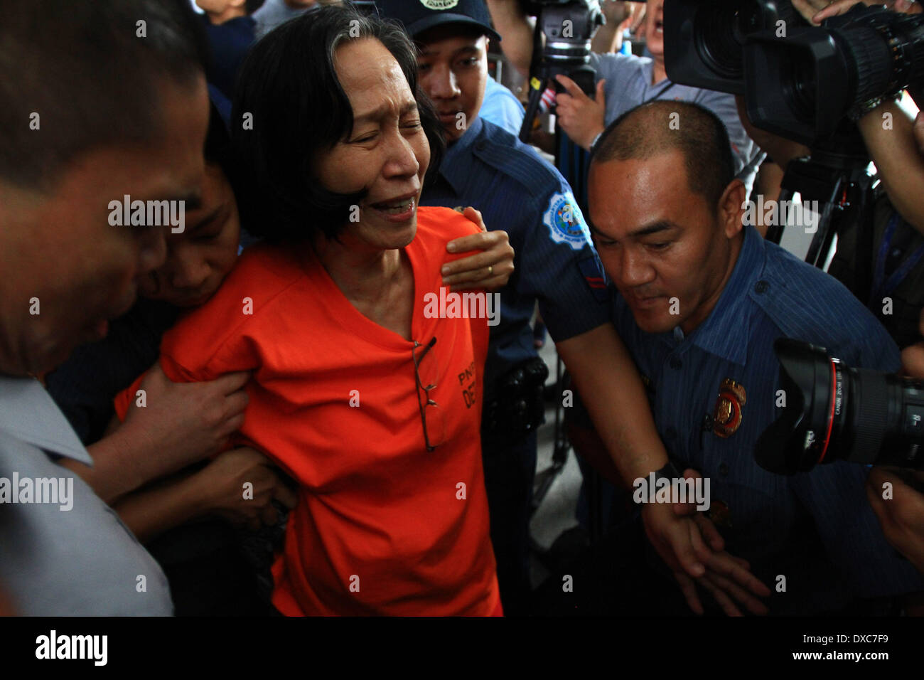 Quezon City, Philippines. 24th Mar, 2014. Wilma Tiamzon (C), secretary general of the Communist Party of the Philippines (CPP)-NPA, reacts as she is taken by policemen into a police van after inquest proceeding at Camp Crame in Quezon City, the Philippines, March 24, 2014. The Communist Party of the Philippines, New People's Army and National Democratic Front (CPP-NPA-NDF) vowed Monday to pursue armed struggle despite the arrest of their two top leaders. Credit:  Rouelle Umali/Xinhua/Alamy Live News Stock Photo
