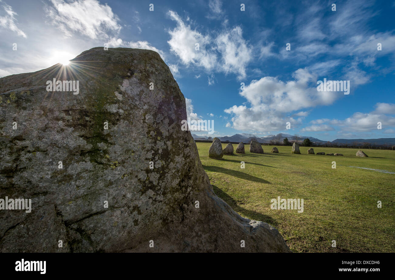 Sun over one of the standing stones at Castlerigg Stone Circle, nr Keswick, Cumbria Stock Photo