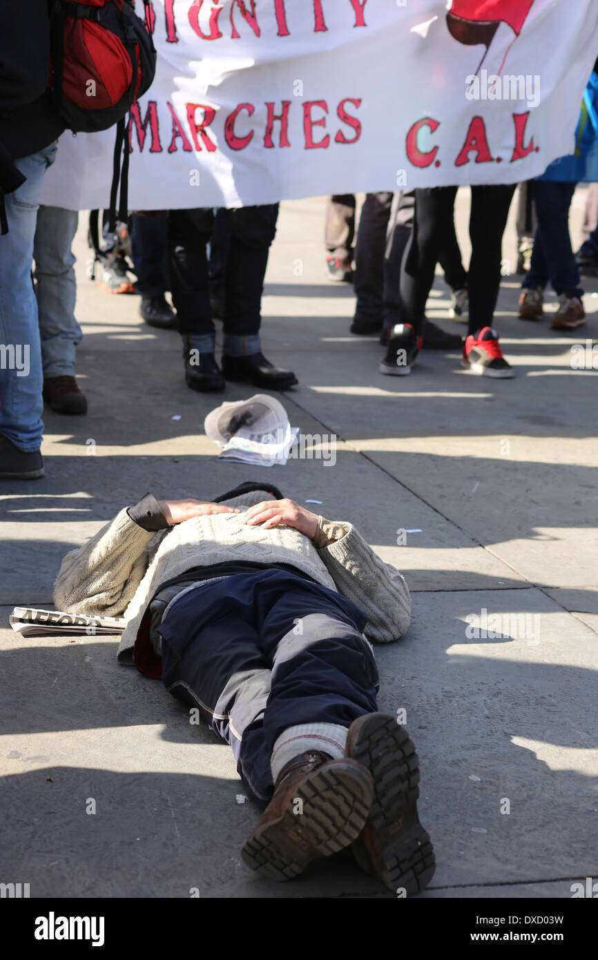 White caucassian homeless lying, apparently sleeping in floor in middle of Demonstration in Trafalgar Square Stock Photo