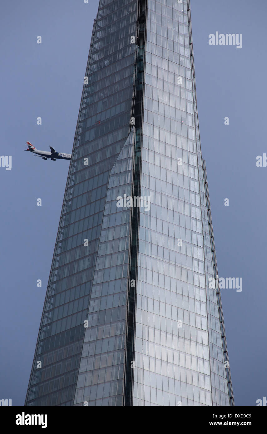 Plane flying very close to the Shard Building in London Stock Photo