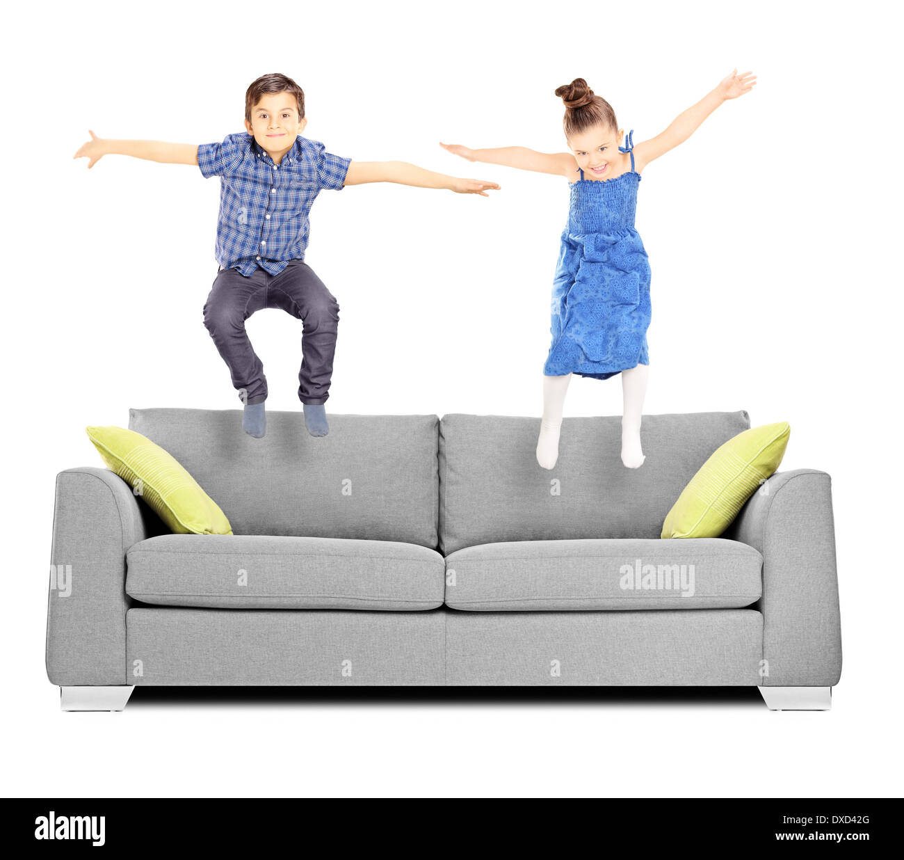 Brother and sister jumping on sofa Stock Photo