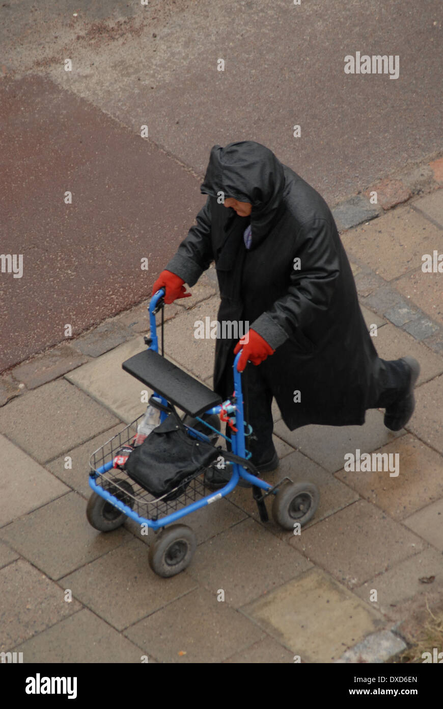 Walking with zimmer frame in rain. Stock Photo