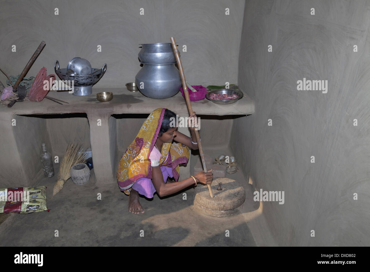 Tribal woman grinding grains with stone grinder. Santhal tribe. Jarkatand village, Bokaro district, Jharkhand Stock Photo