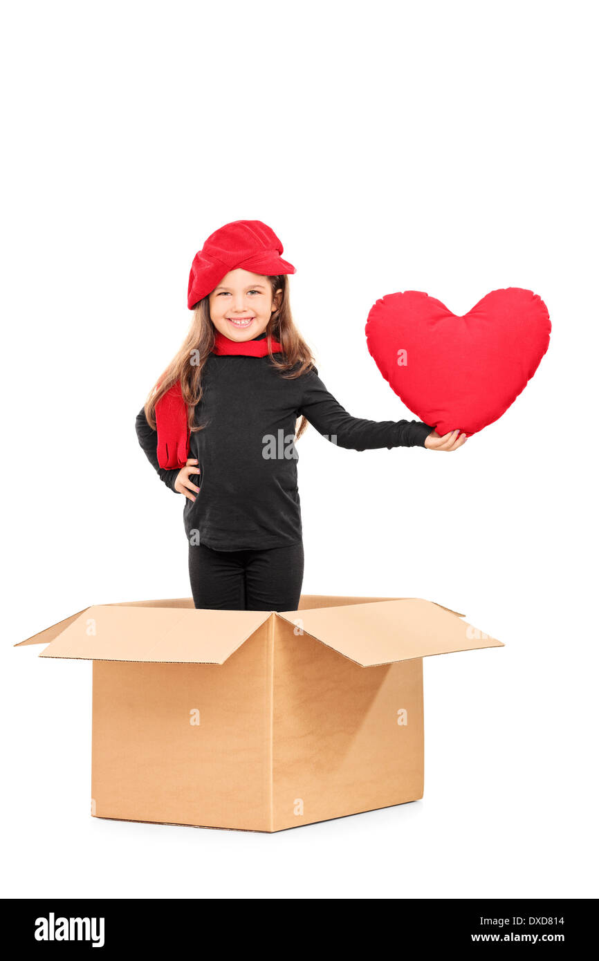 Little girl standing in a box and holding a red heart Stock Photo