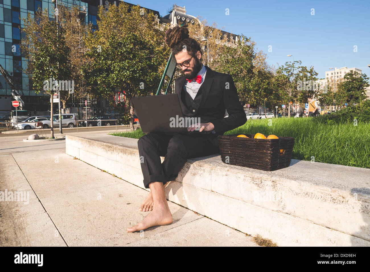 Stylish elegant dreadlocks businessman using notebook in business landscape Stock Photo