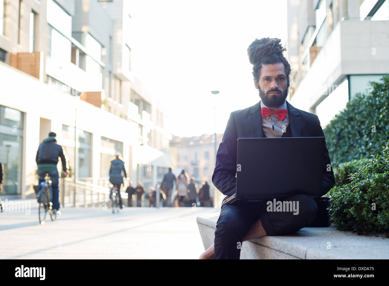 Stylish elegant dreadlocks businessman using notebook in business landscape Stock Photo