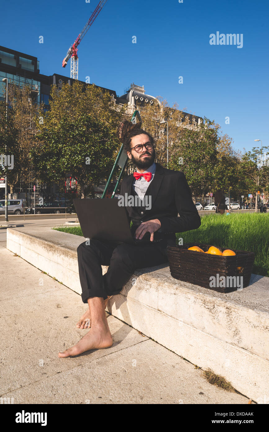 Stylish elegant dreadlocks businessman using notebook in business landscape Stock Photo