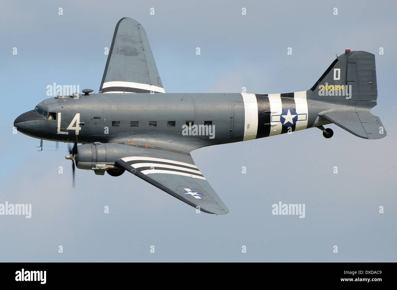 Douglas C-47 Skytrain plane in period camouflage markings including D Day 'invasion stripes'. Second World War transport plane flying at airshow Stock Photo