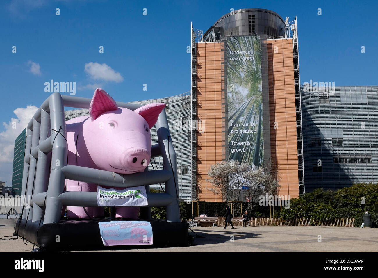 A giant inflated pig in a cage stands near the EU headquarters where the European Agriculture ministers gather for their council meeting in Brussels, Belgium on 24.03.2014 The pig is set up by animal rights activists of Compassion in World Farming (CIWF) who protest to raise awareness for the plight of pigs in countries where they are suffering in illegal and inhumane conditions. by Wiktor Dabkowski Stock Photo