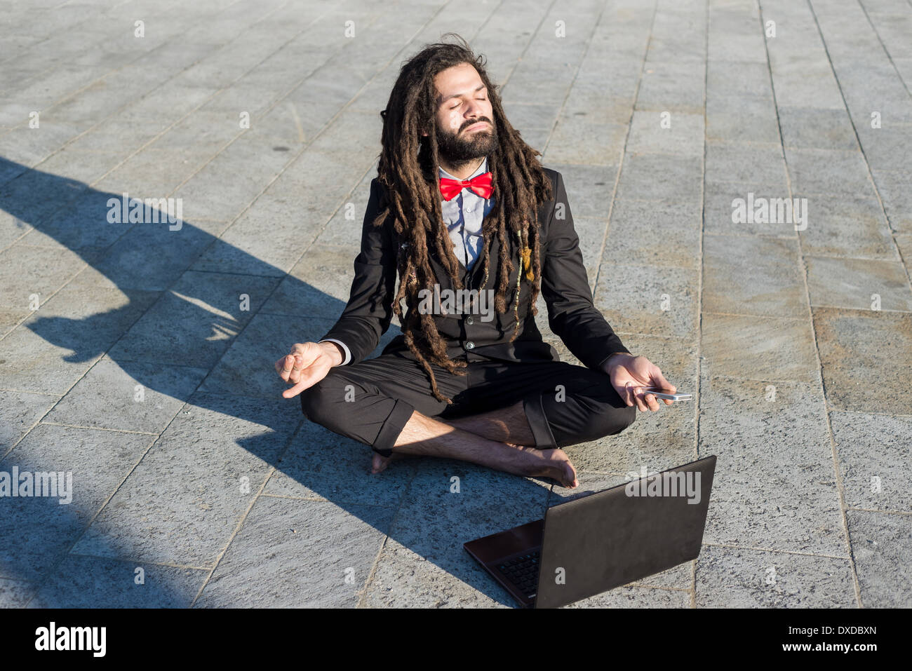 Stylish elegant dreadlocks businessman using notebook in business landscape Stock Photo