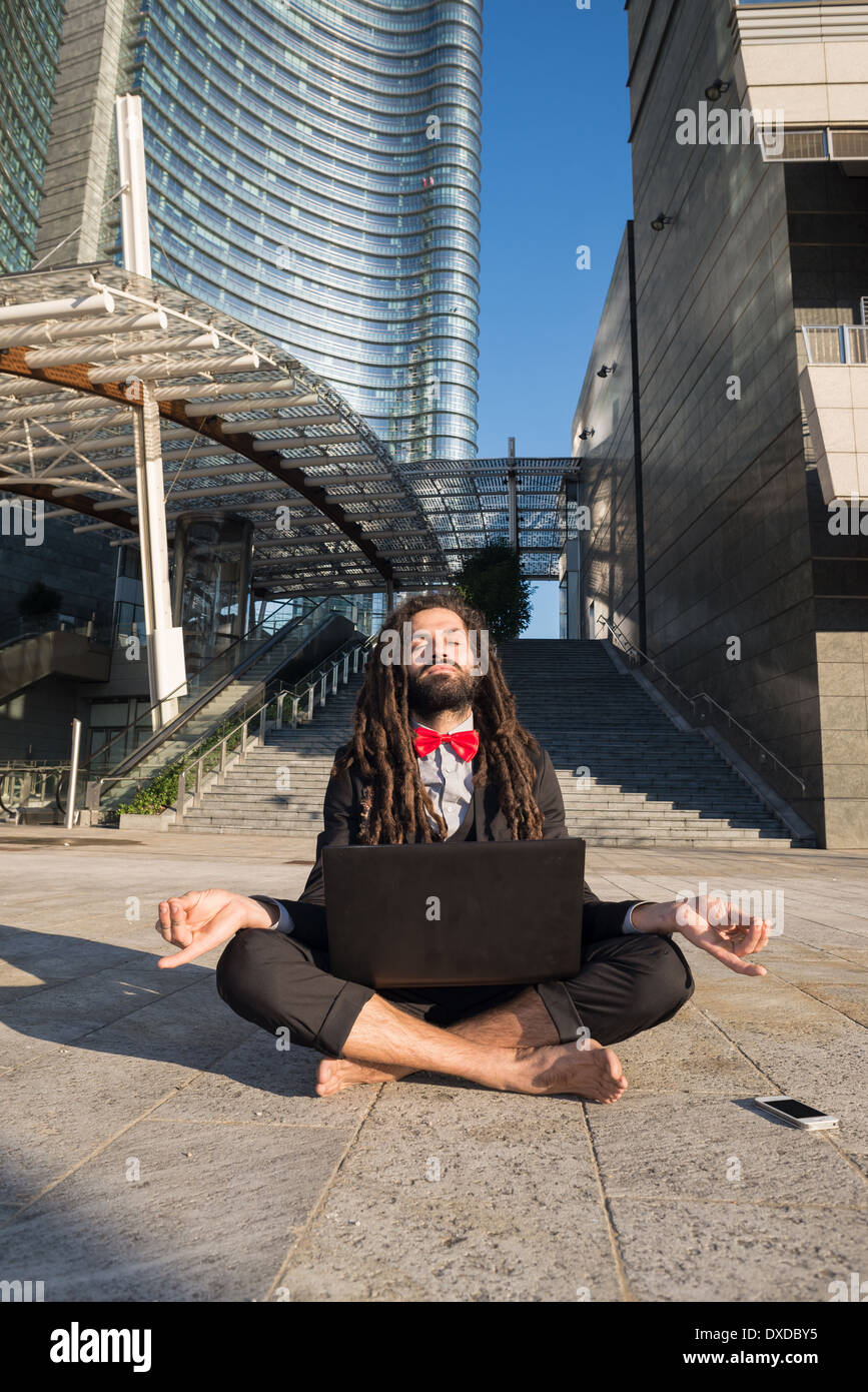 Stylish elegant dreadlocks businessman using notebook in business landscape Stock Photo