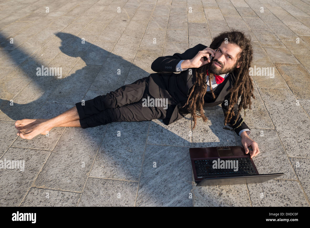 Stylish elegant dreadlocks businessman using notebook in business landscape Stock Photo