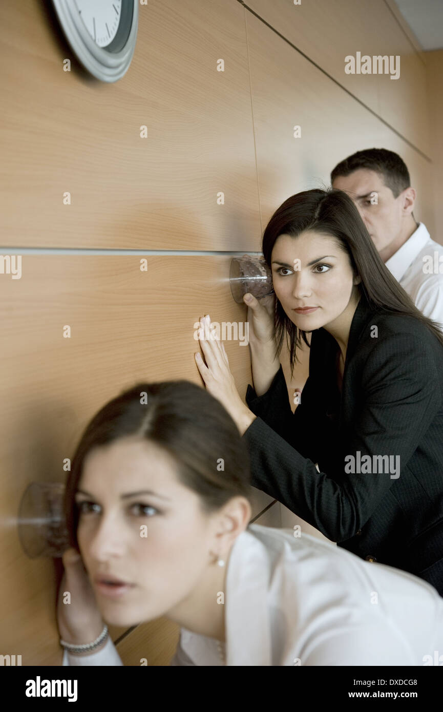 Office workers eavesdropping against wall Stock Photo - Alamy