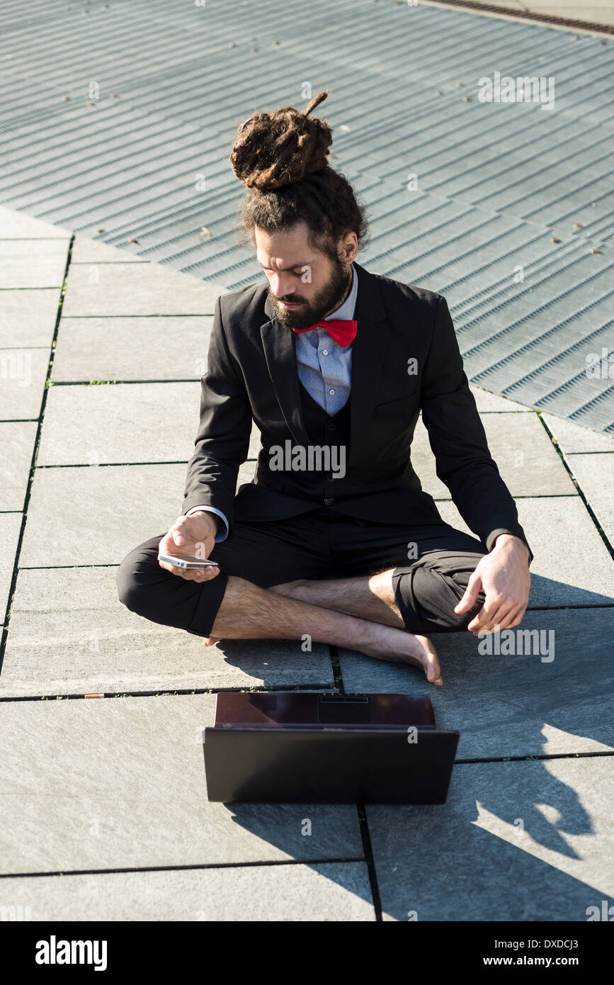 Stylish elegant dreadlocks businessman using notebook in business landscape Stock Photo