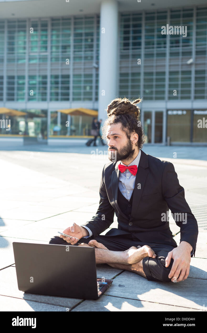 Stylish elegant dreadlocks businessman using notebook in business landscape Stock Photo