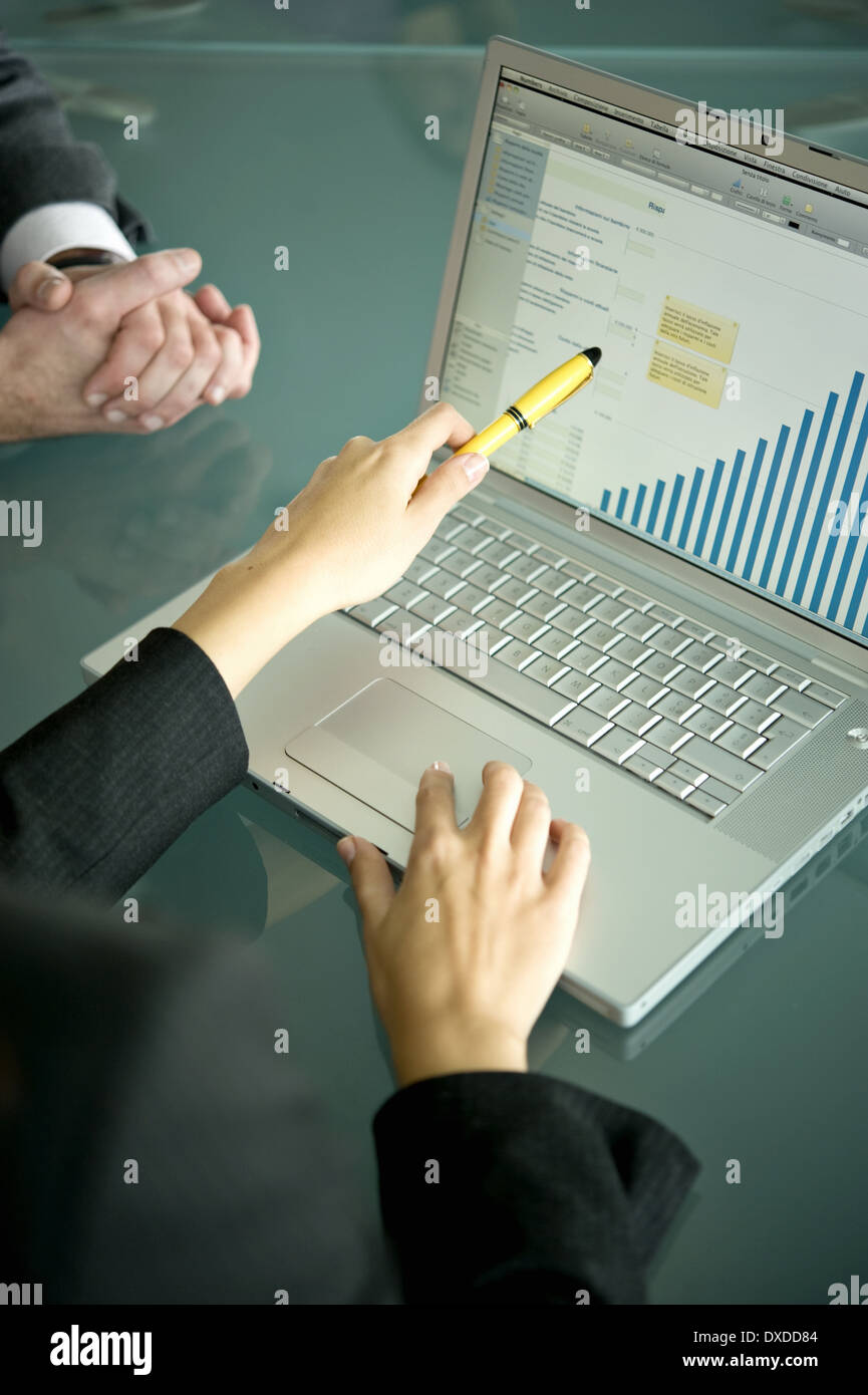 Business people's hands with laptop showing bar chart Stock Photo
