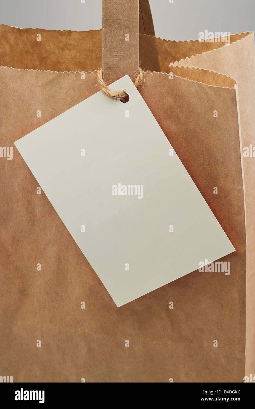 Brown paper bag with blank tag attached for your personal message or company branding Stock Photo