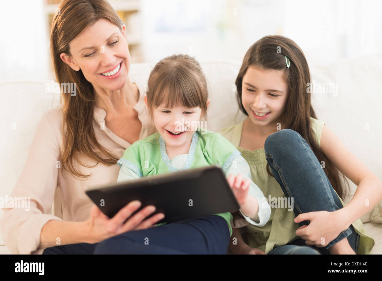 Mother and daughters (4-5,8-9) using tablet pc Stock Photo