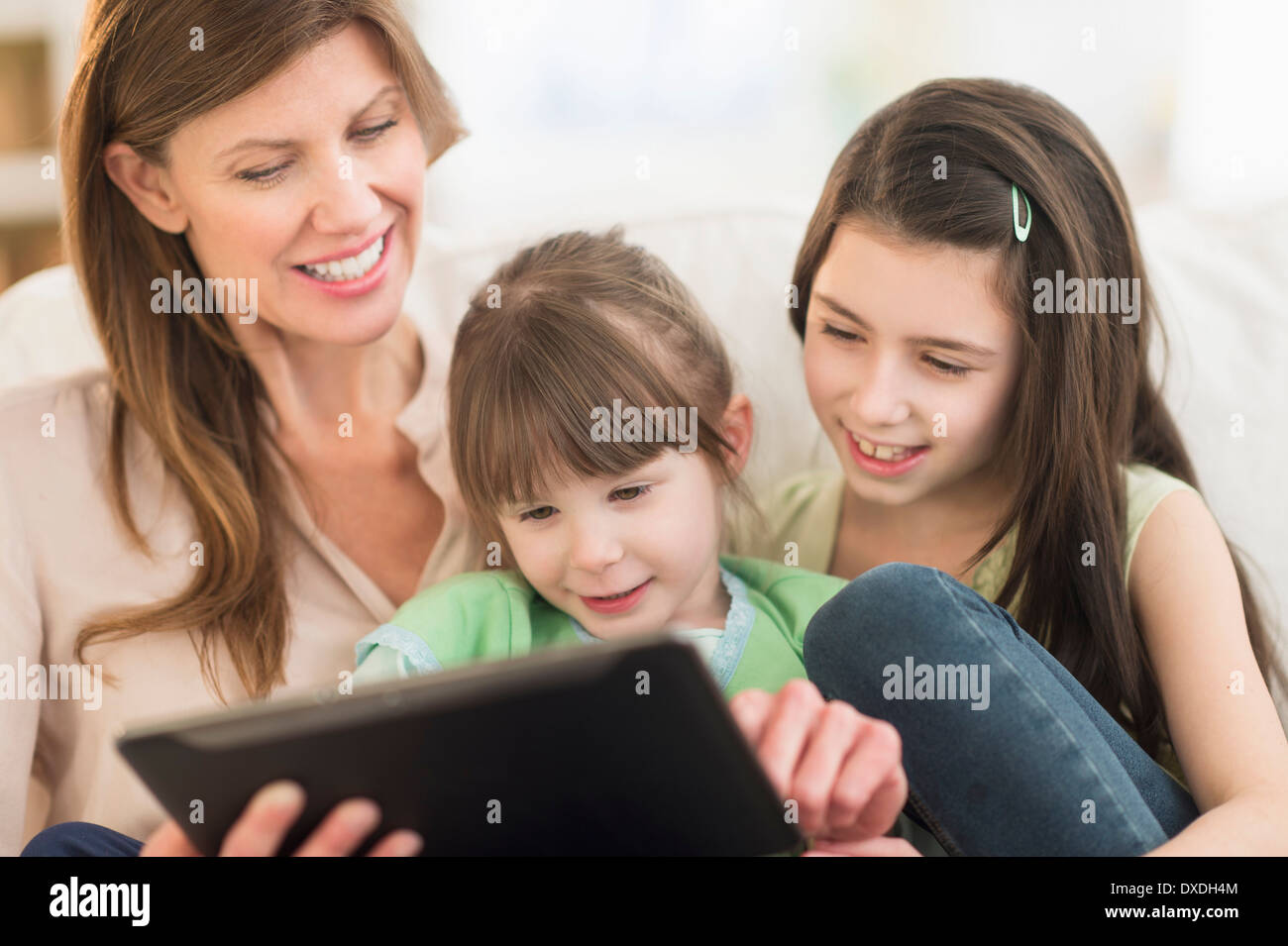 Mother and daughters (4-5,8-9) using tablet pc Stock Photo