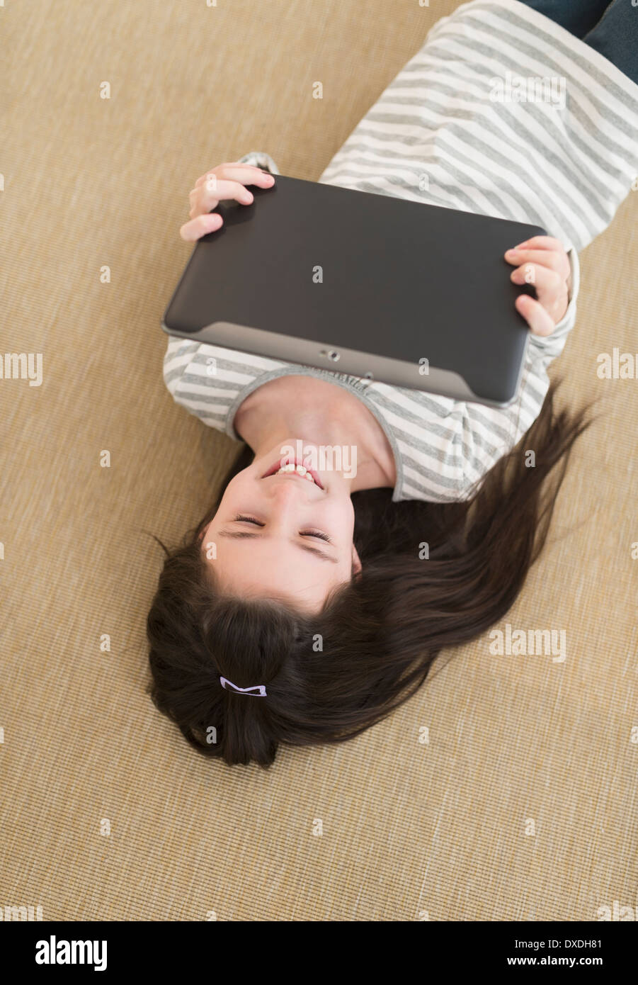 Girl (8-9) lying on floor using tablet pc Stock Photo